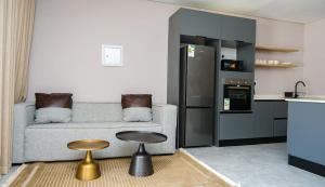 a living room with a couch and a table and a kitchen at Mupauli Boutique Lodge in Hartbeesbult
