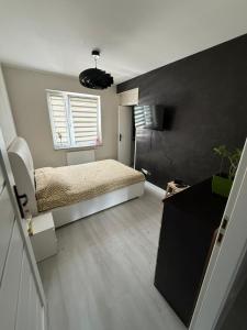 een slaapkamer met een bed en een zwarte muur bij PFB Premium Apartment in Słubice