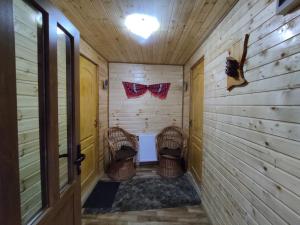 a room with two wicker chairs in a wooden house at Cabana doi mesteceni in Drumu Carului +141 photos