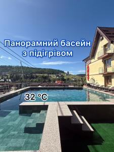 a swimming pool in front of a building at Villa Anet in Bukovel