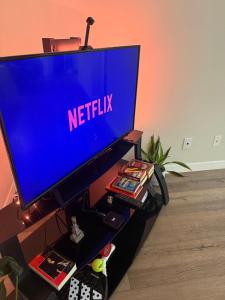 een flatscreen-tv zittend op een tv-stand bij Cé La Vie in Québec
