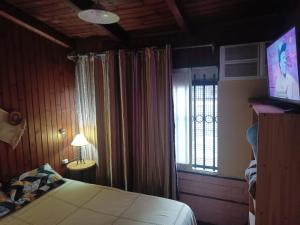 a bedroom with a bed and a window and a television at Hostería Don Atilio in Posadas