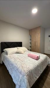 a bedroom with a large bed with a pink towel on it at Suite Prado-PC0n Garant1a in Cochabamba