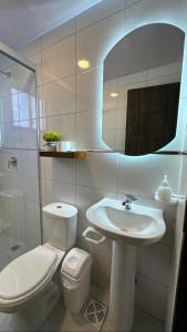 a bathroom with a sink and a toilet and a mirror at Suite Prado-PC0n Garant1a in Cochabamba
