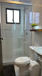 a white bathroom with a toilet and a sink at Suite Prado-PC0n Garant1a in Cochabamba