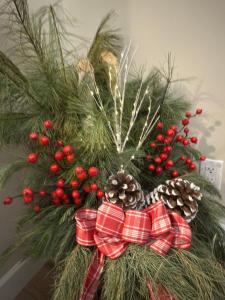 een kerstkrans met rode bessen en dennenappels bij Cé La Vie in Québec