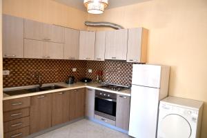 a kitchen with wooden cabinets and a white refrigerator at Coastal Calm in Golem