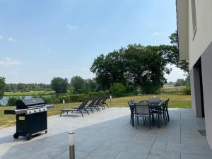 un patio avec une table, des chaises et un barbecue dans l'établissement Chambres d'hôtes bord de Saône, à Lamarche-sur-Saône 8 autres photos