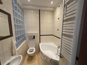 a bathroom with a sink and a toilet and a tub at Willa Marie in Krynica Zdrój +34 photos