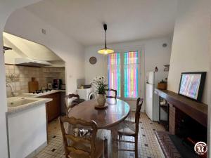 een keuken met een tafel en stoelen in een keuken bij La sapinette in Quillan +3 foto's