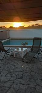 een paar stoelen en een tafel en een zwembad bij Casa rural El Candil in Olivenza