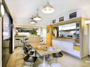 een keuken met een tafel en stoelen en een aanrecht bij hotelF1 Brive Ussac in Ussac