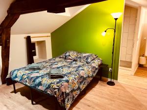 ein Schlafzimmer mit einem Bett und einer grünen Wand in der Unterkunft Comme chez soi - Emplacement #1 et Grand Confort in Feurs