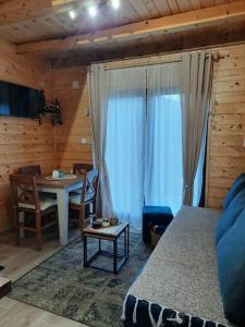 een slaapkamer met een bed en een tafel en stoelen bij Vikendica Neven 3 in Popovići +2 foto's
