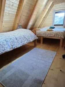 een kamer met twee bedden in een houten hut bij Vikendica Neven 3 in Popovići