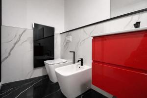 ein Badezimmer mit einem weißen Waschbecken und einem roten Schrank in der Unterkunft Maison Valentino in Mailand