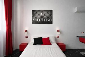 ein Schlafzimmer mit einem weißen Bett mit roten Akzenten in der Unterkunft Maison Valentino in Mailand