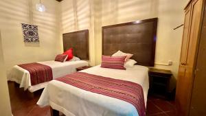 two beds in a small room with at Casona Bartolome in Morelia +5 photos