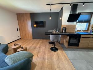 a living room with a couch and a kitchen at woidpanorama 3 Appartement in Neuschönau