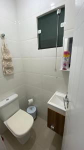 a white bathroom with a toilet and a sink at Pensionato Marlu I in Balneário Camboriú +12 photos