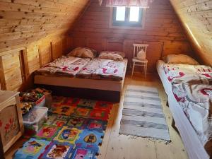 a bedroom with two beds and a rug in a log cabin at Chalupka u macka in Párnica