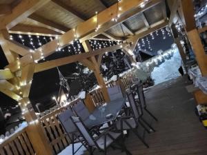 a table and chairs on a deck with lights at Chalupka u macka in Párnica