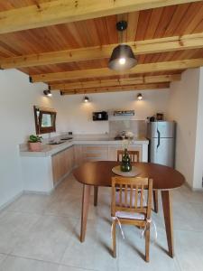 a kitchen with a wooden ceiling and a wooden table and chairs at Las Calandrias II in Los Reartes