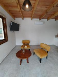 a room with two chairs and a table and a tv at Las Calandrias II in Los Reartes