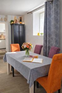a dining room table with a vase of flowers on it at Enjoy en Champagne maison calme au milieu du vignoble avec parking gratuit in Dormans +28 photos
