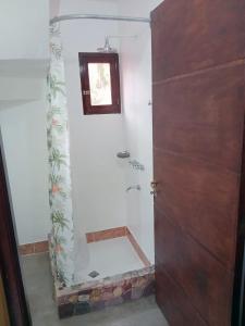 a bathroom with a shower with a glass door at Alojamiento La Oti in Tilcara