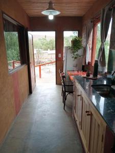 a kitchen with a counter with a sink and a table at Alojamiento La Oti in Tilcara +12 photos