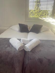 een bed met twee witte kussens erop met een raam bij Le rocher in Sierre