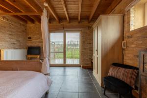 een slaapkamer met een bed en een groot raam bij B&B De Leestjespolder in Moerkerke