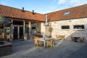 een terras met een tafel en stoelen en een gebouw bij B&B De Leestjespolder in Moerkerke