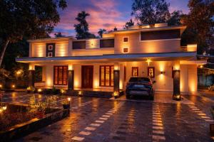 een huis met een auto ervoor geparkeerd bij PATHIRAMANAL Service Villas in Alleppey