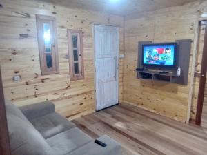 un soggiorno con un divano e una TV di Morada do Verão a Imbé