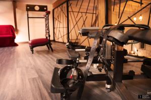 une salle de sport avec un banc et une chaise dans l'établissement Maison des Soupirs, à Montpon-Ménestérol