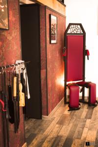 Cette chambre est dotée d'un mur rouge avec une table et des chaises. dans l'établissement Maison des Soupirs, à Montpon-Ménestérol 3 autres photos