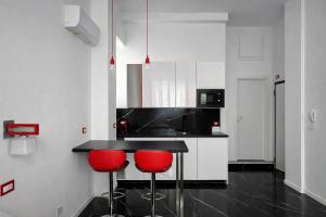 eine Küche mit zwei roten Stühlen an einer Theke in der Unterkunft Maison Valentino in Mailand