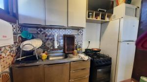 una piccola cucina con fornelli e lavello di Cabana Raio de Sol RS a Osório