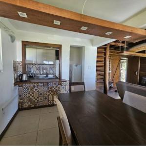una sala da pranzo con un tavolo e una cucina di Cabana Raio de Sol RS a Osório