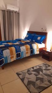 ein Schlafzimmer mit einem Bett mit blauen Laken und blauen Kissen in der Unterkunft DS Residence509 in Bingerville