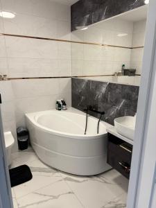 een witte badkamer met een bad en een wastafel bij PFB Premium Apartment in Słubice