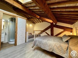 une chambre avec un lit dans une pièce avec des plafonds en bois dans l'établissement La ruche, à Durban-Corbières