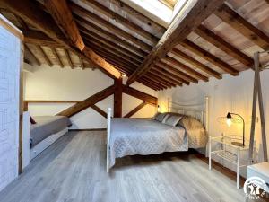 une chambre avec deux lits dans une pièce avec des plafonds en bois dans l'établissement La ruche, à Durban-Corbières 3 autres photos
