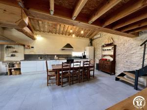 une cuisine avec une table et des chaises dans une pièce dans l'établissement La ruche, à Durban-Corbières