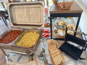 een tafel met veel verschillende soorten voedsel bij Pousada Ponta dos Corais in Guarujá