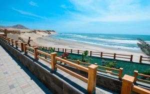 a wooden fence next to a beach with the ocean at Sunset bed in Puerto Chicama
