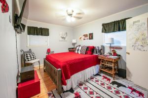 a bedroom with a red bed with a red blanket at Hot Tub, Fire Pit and Lake Access! Almond Cabin in Almond