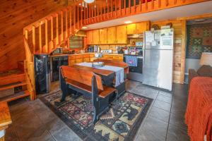 a kitchen with a table and a refrigerator at Hot Tub, Fire Pit and Lake Access! Almond Cabin in Almond